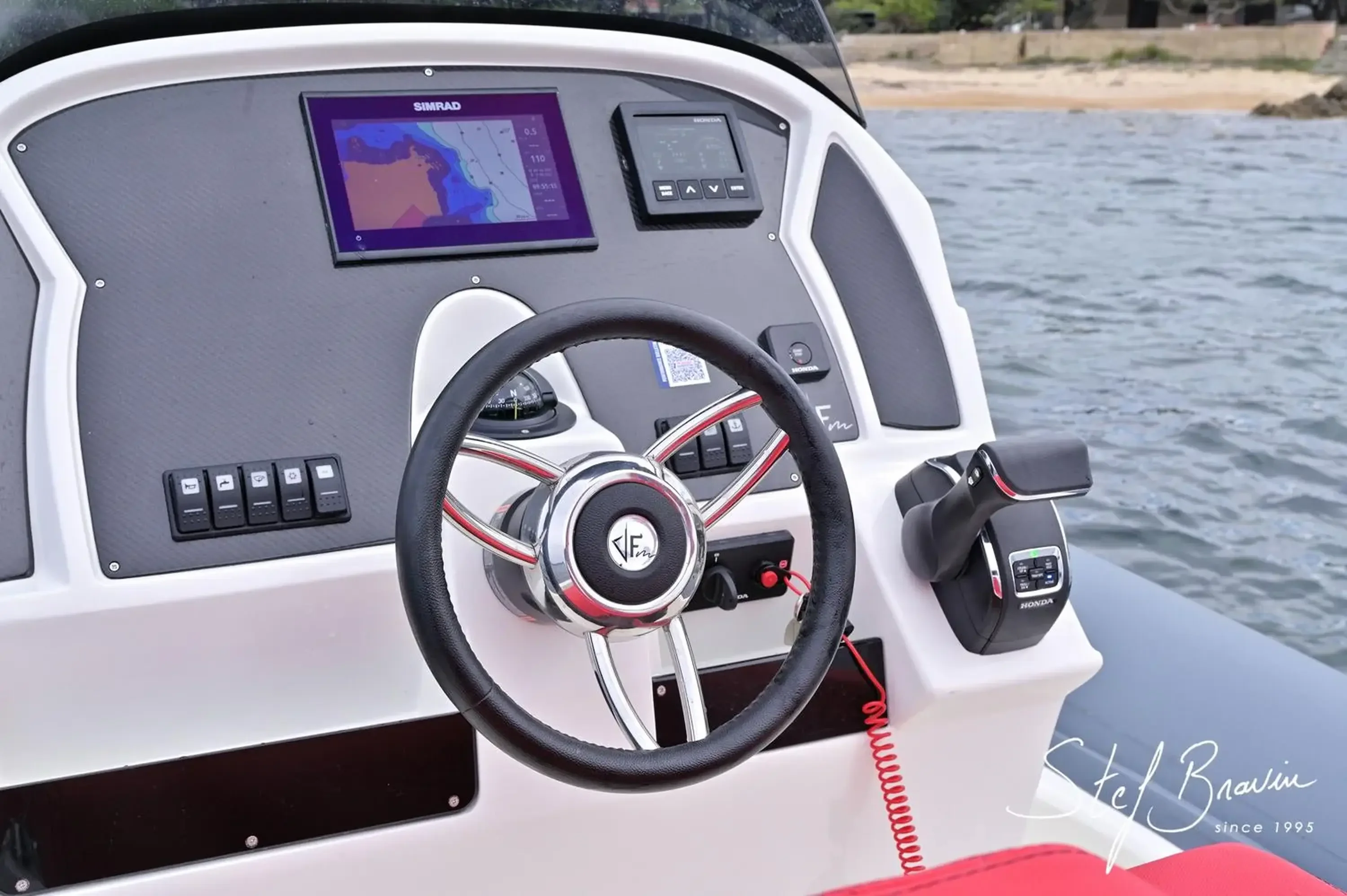 Poste de pilotage de l'Alpana 820 avec écran Simrad, volant et commande Honda