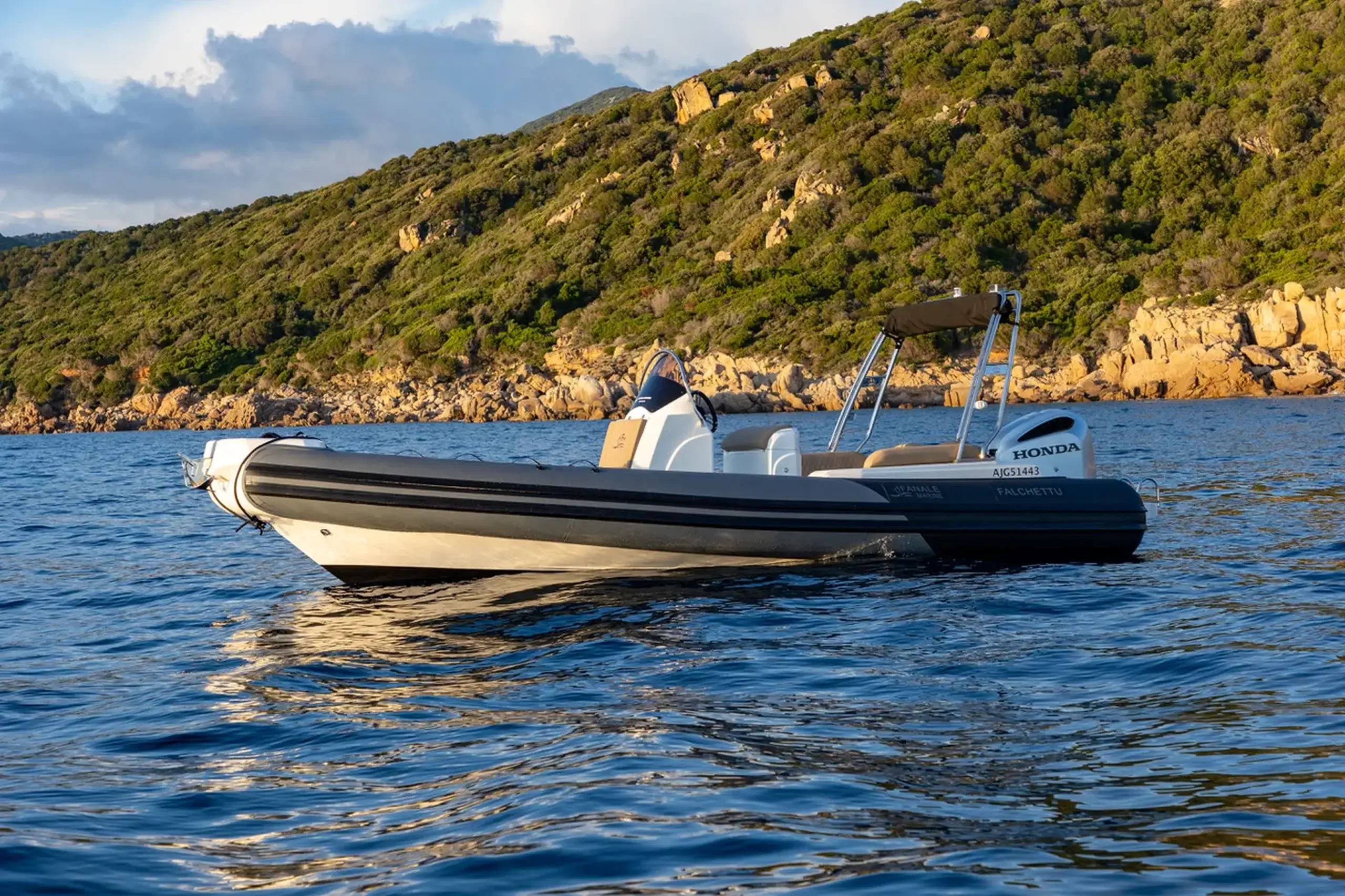 Fanale Falchettu 700 au mouillage devant une côte rocheuse au coucher du soleil